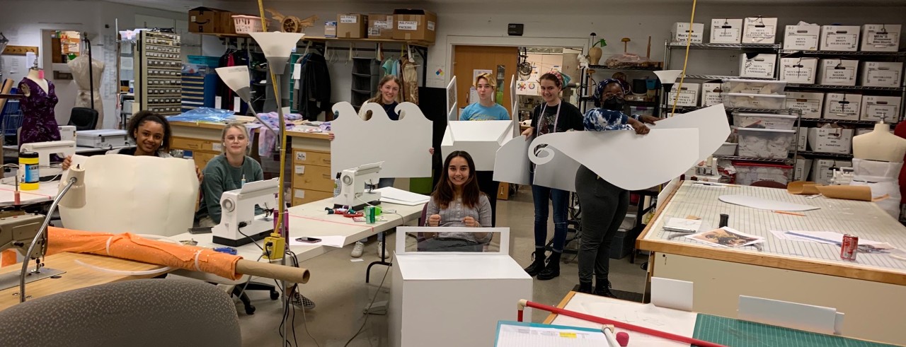 UC students pose for a photo in CCM's Scene Shop, where they are using their creative expertise and skills to build customized costumes for May We Help’s annual Halloween Festival.