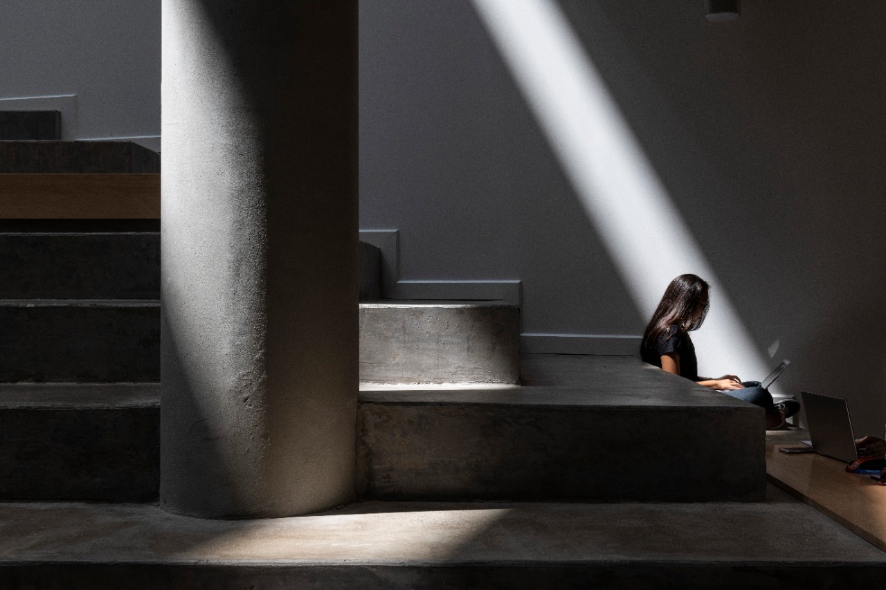 A student sits alone at the Carl H. Lindner College of Business.