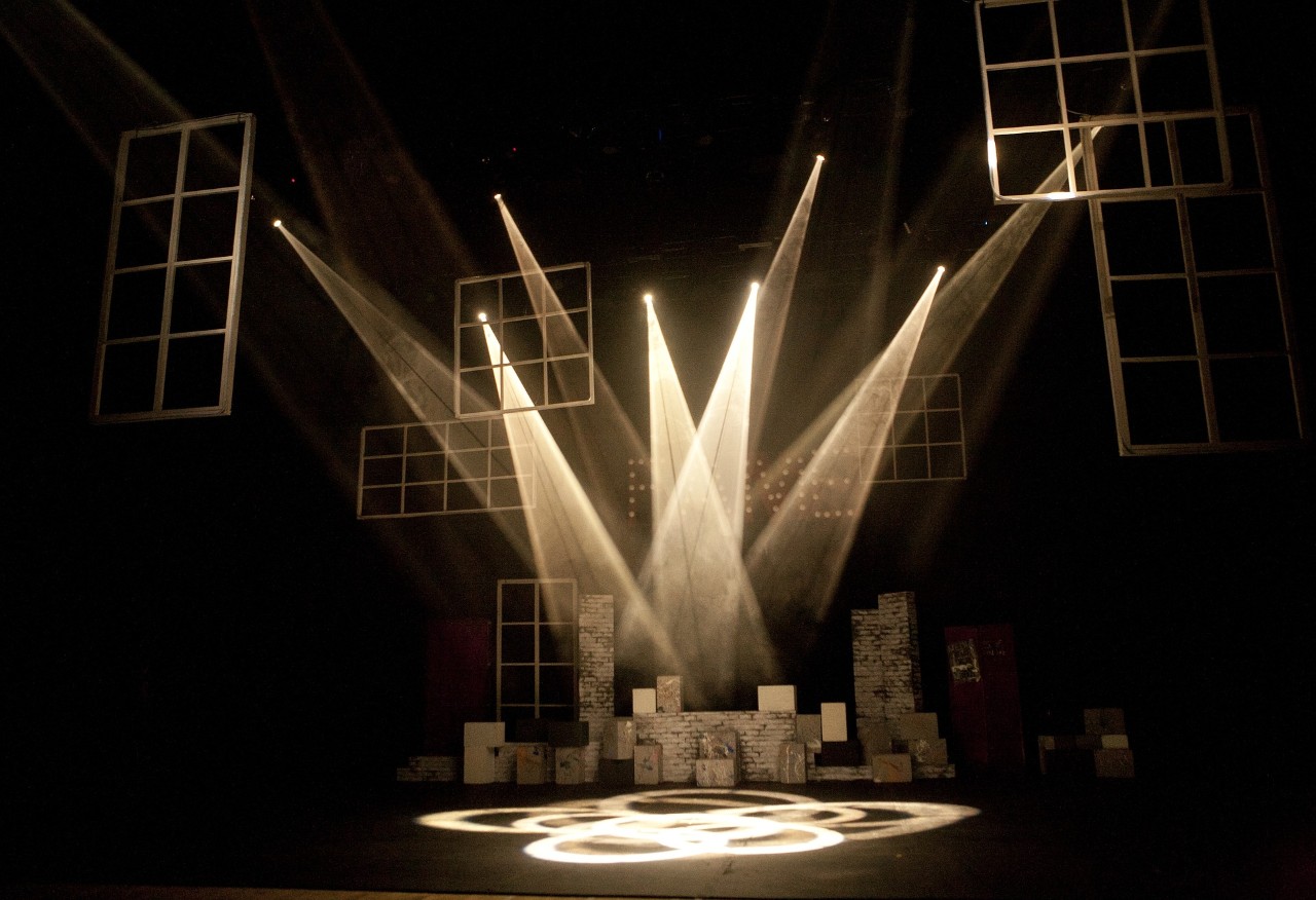 Theater lights shine on an empty stage.