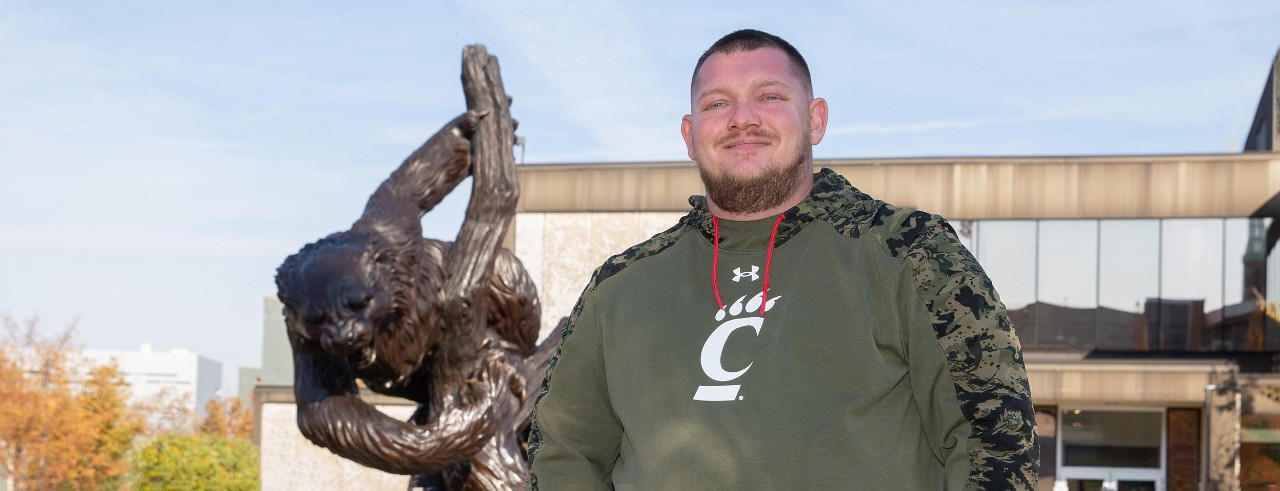 UC student veteran Tim Fancote Jr. poses in front of the Bearcat statue.