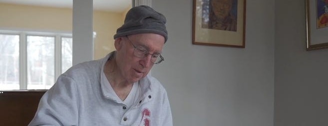 Alan Jobe sits at a table and looks through a book