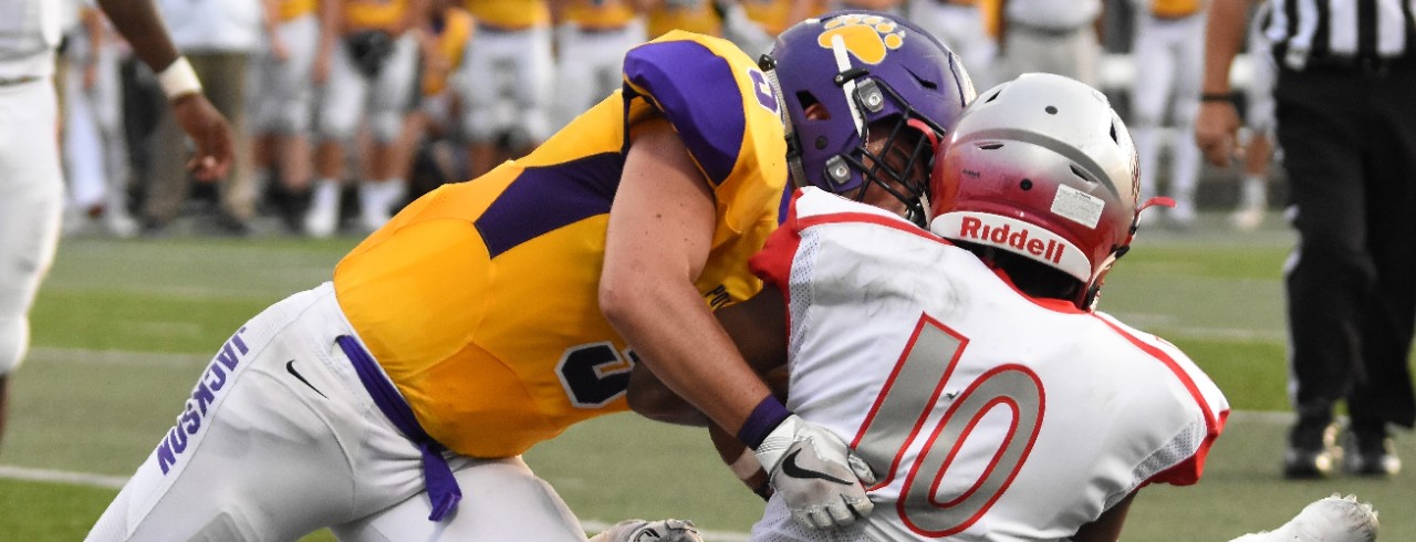 A football player makes a tackle.