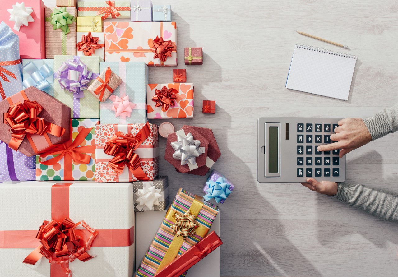 A stock photo of a person calculating their holiday purchases.