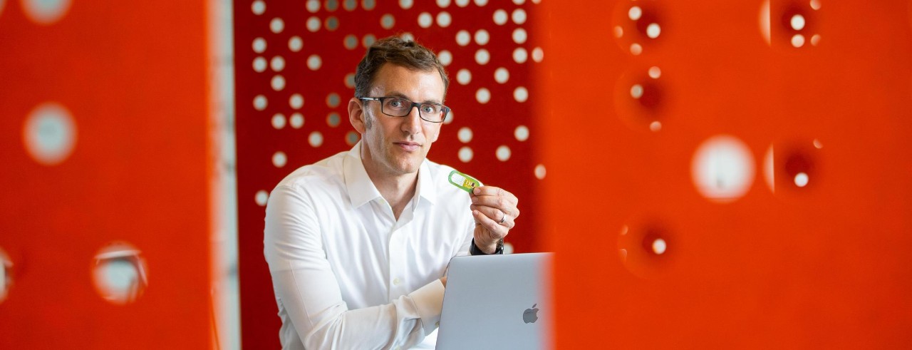 Jason Heikenfeld holds up a sensor at the 1819 Innovation Hub.