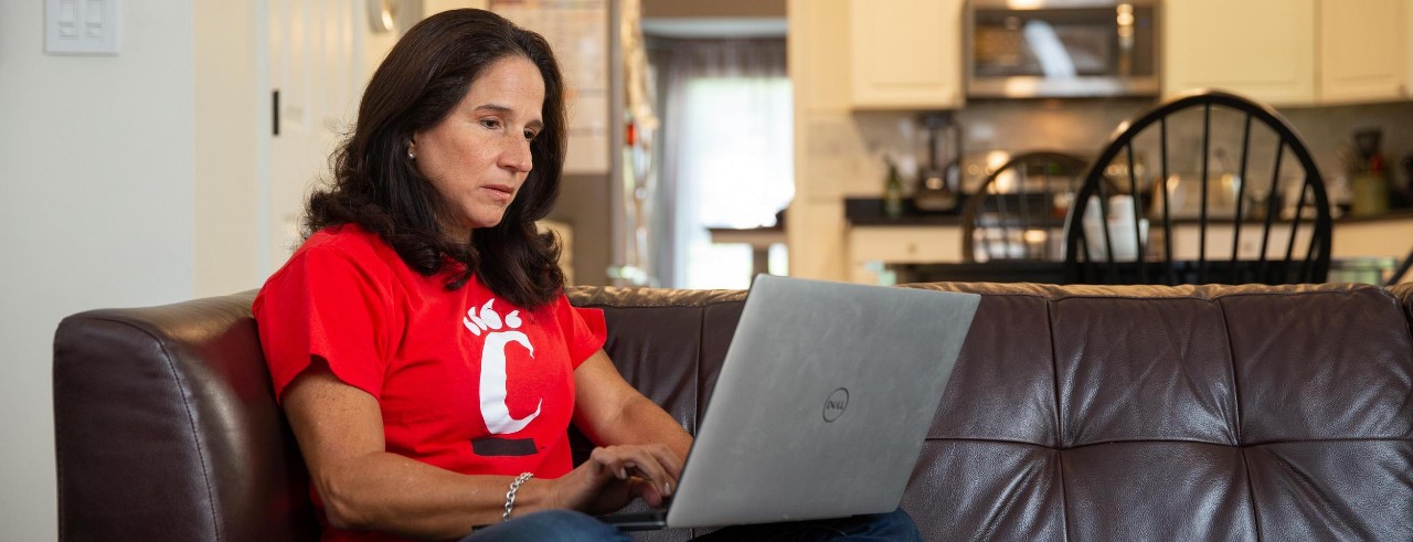 A woman works on a laptop in her home.