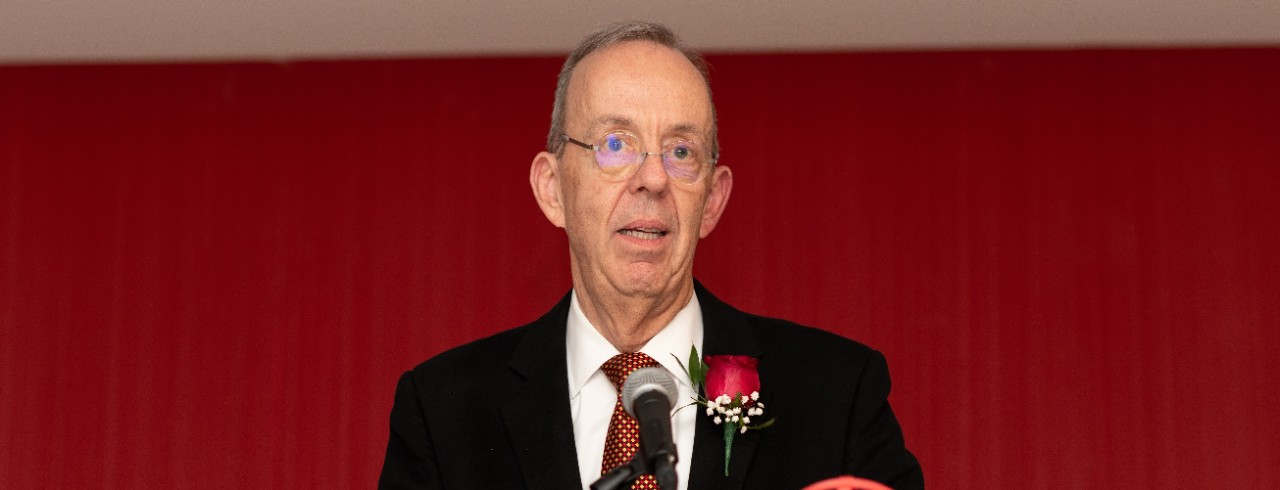 Michael Valentine speaks at a podium in front of microphone