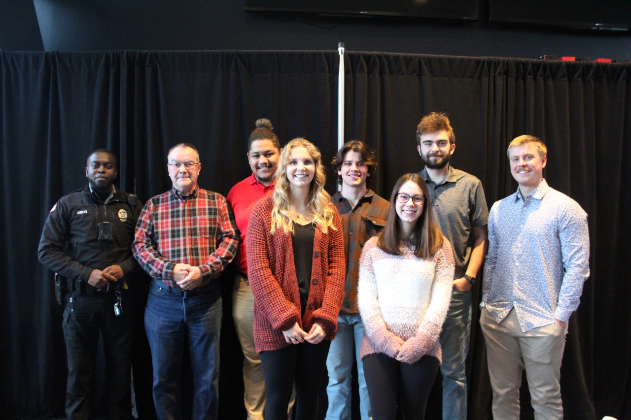 A UC Police officer and Campus Recreation staff pose with Mike Murphy at a recent recognition event.