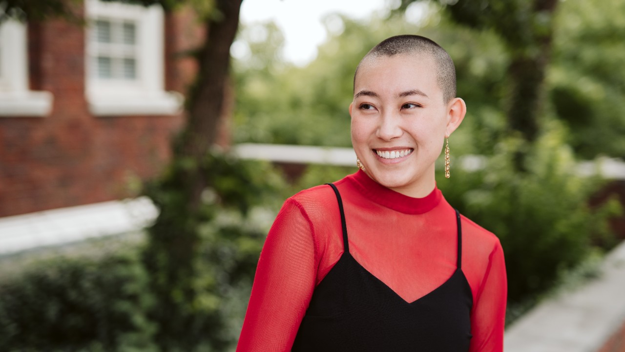 headshot of Hatsue wearing a red turtleneck and black dress