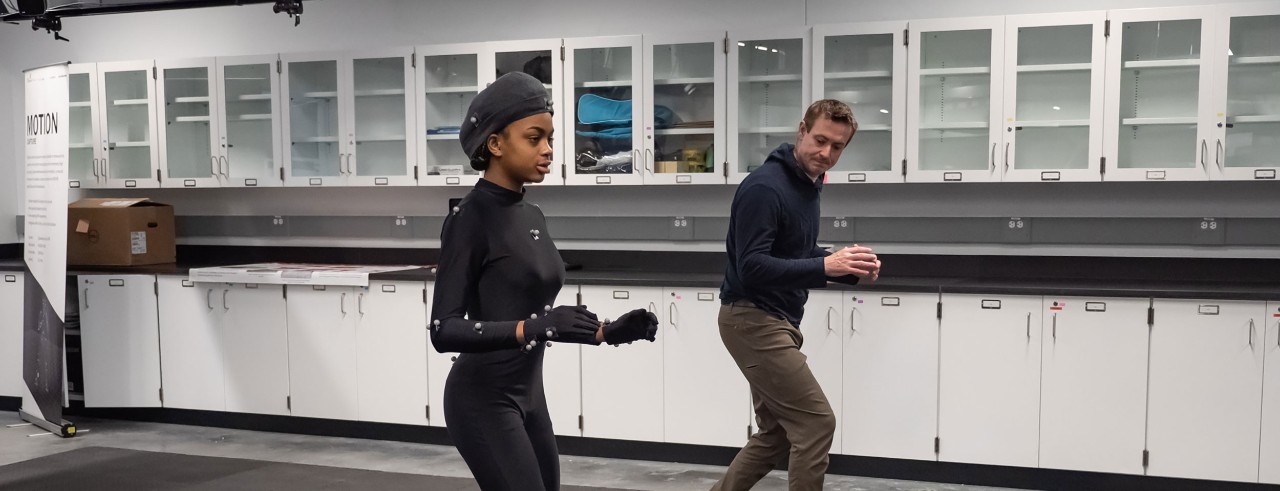 A professor and student pose during a motion capture recording session.