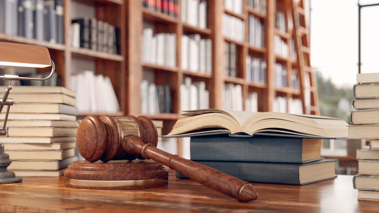 Legal books and gavel on table in library