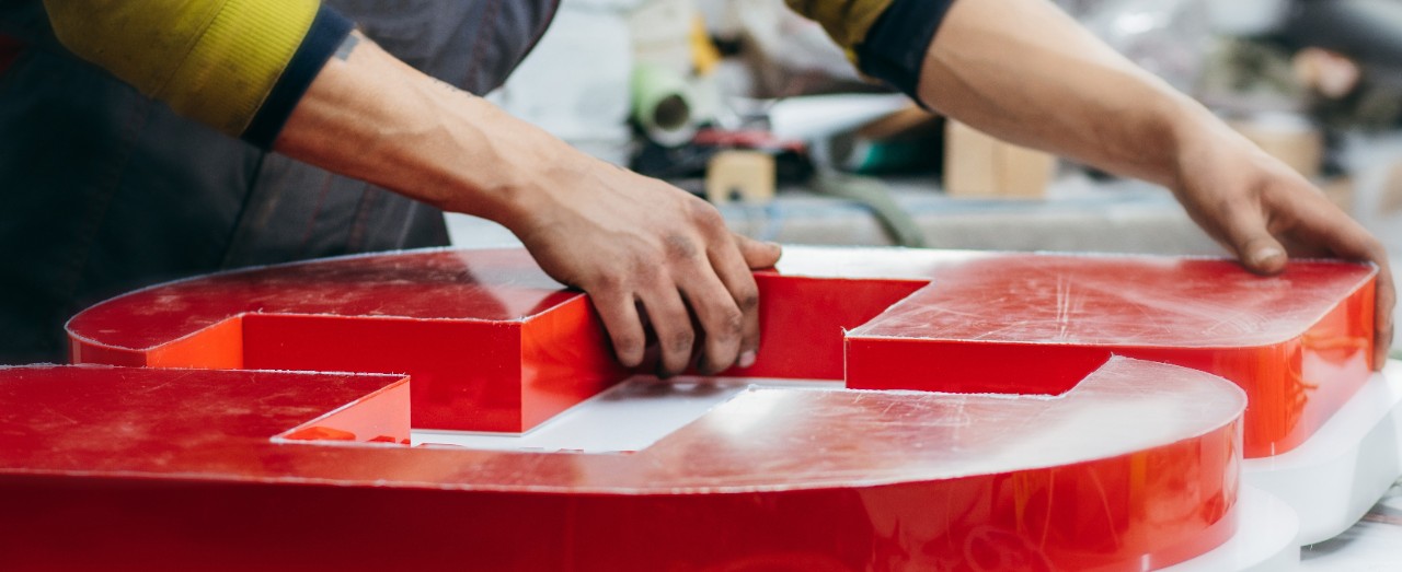 A stock image of a sign industry professional working on a sign.