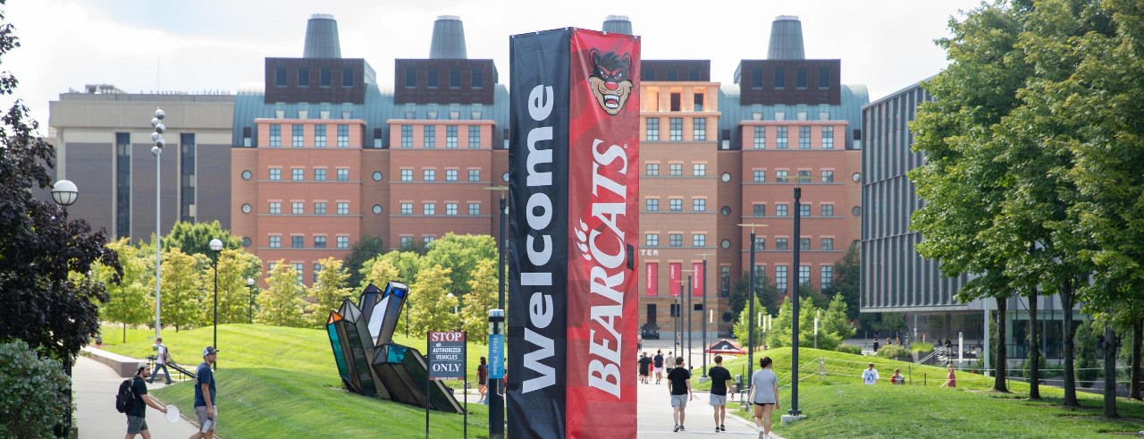 Welcome Bearcats sign and students walking toward the College of Engineering at UC