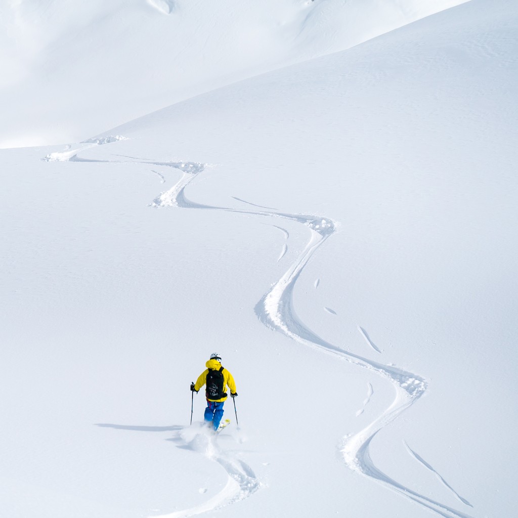 He is paralleling another track down the slope in fresh powder