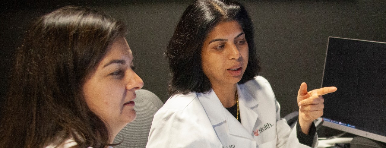 Pooja Khatri and Achala Vagal look at brain scans on a computer monitor