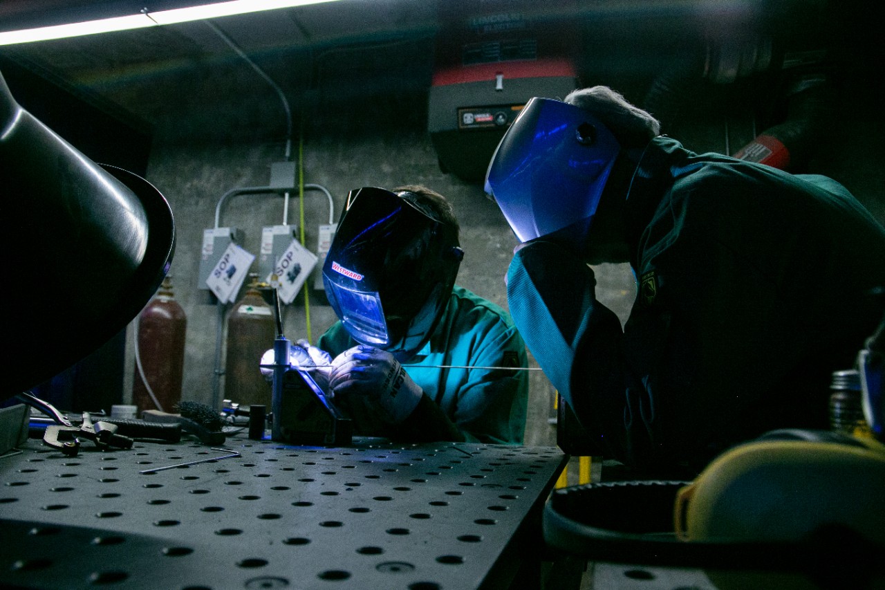 Students welding inside the UC Makerspace