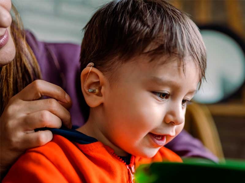 a photo of a child with a hearing aid