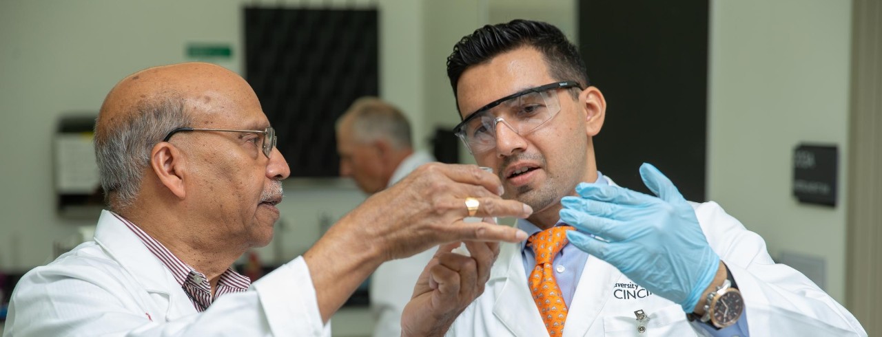 Dr. Ananth and a student look at a mixture in a beaker