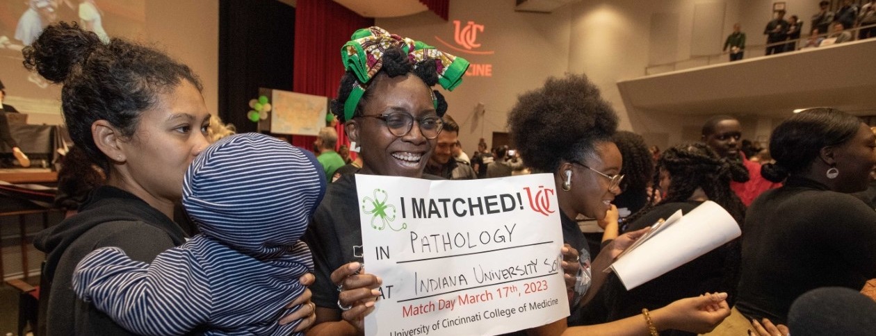 Halimat Olaniyan holds a poster with her match information in Kresge Auditorium