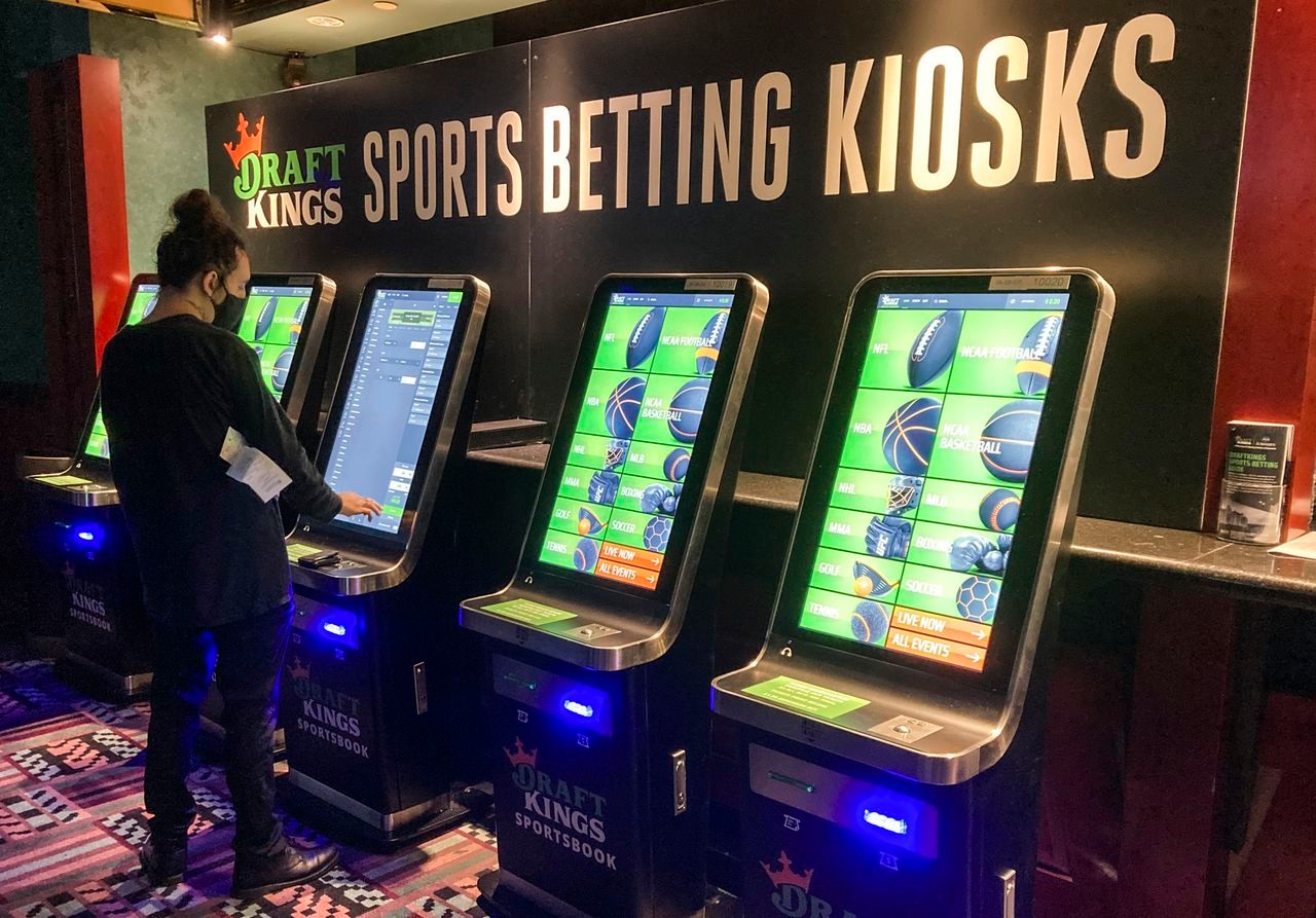 A person standing in front of a sports betting kiosk