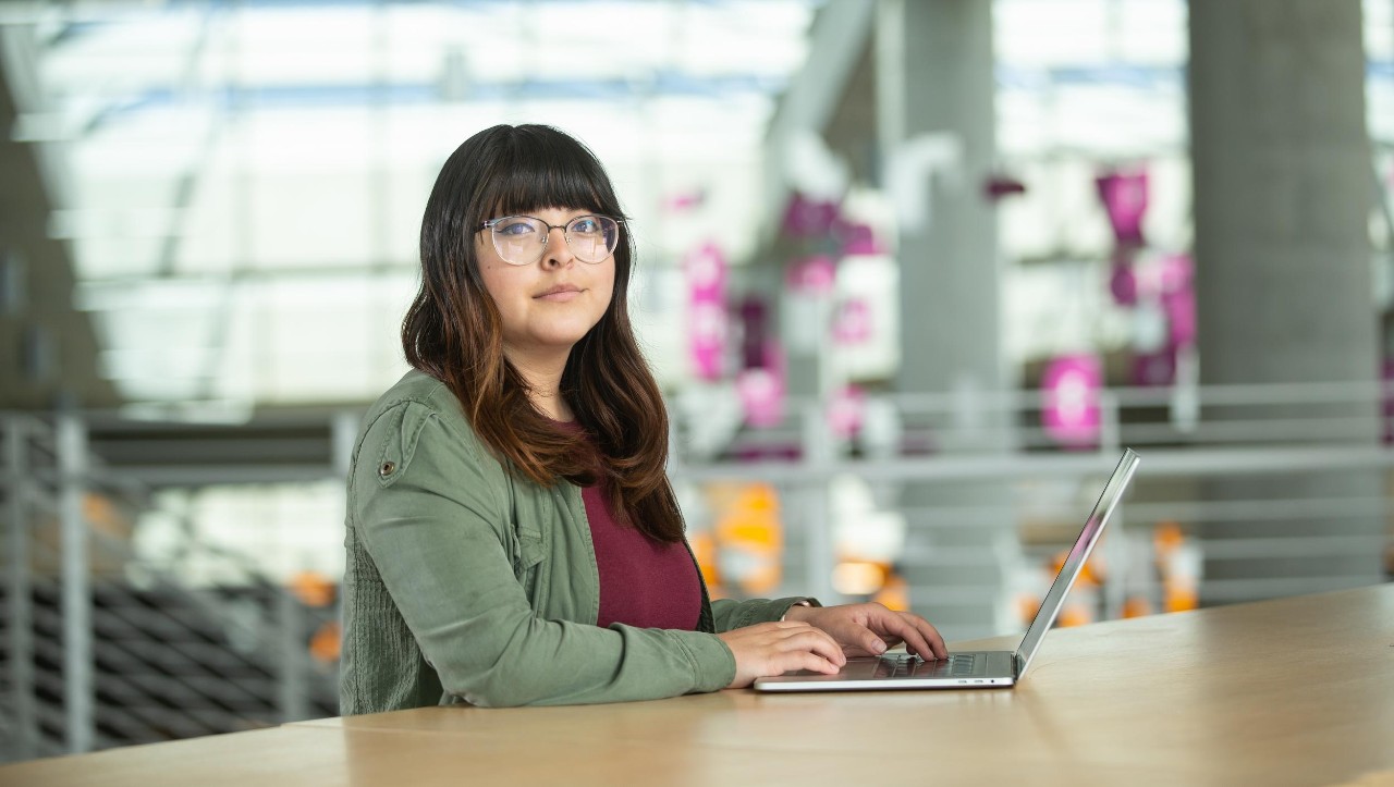 A computer science student at their co-op job working on a laptop.