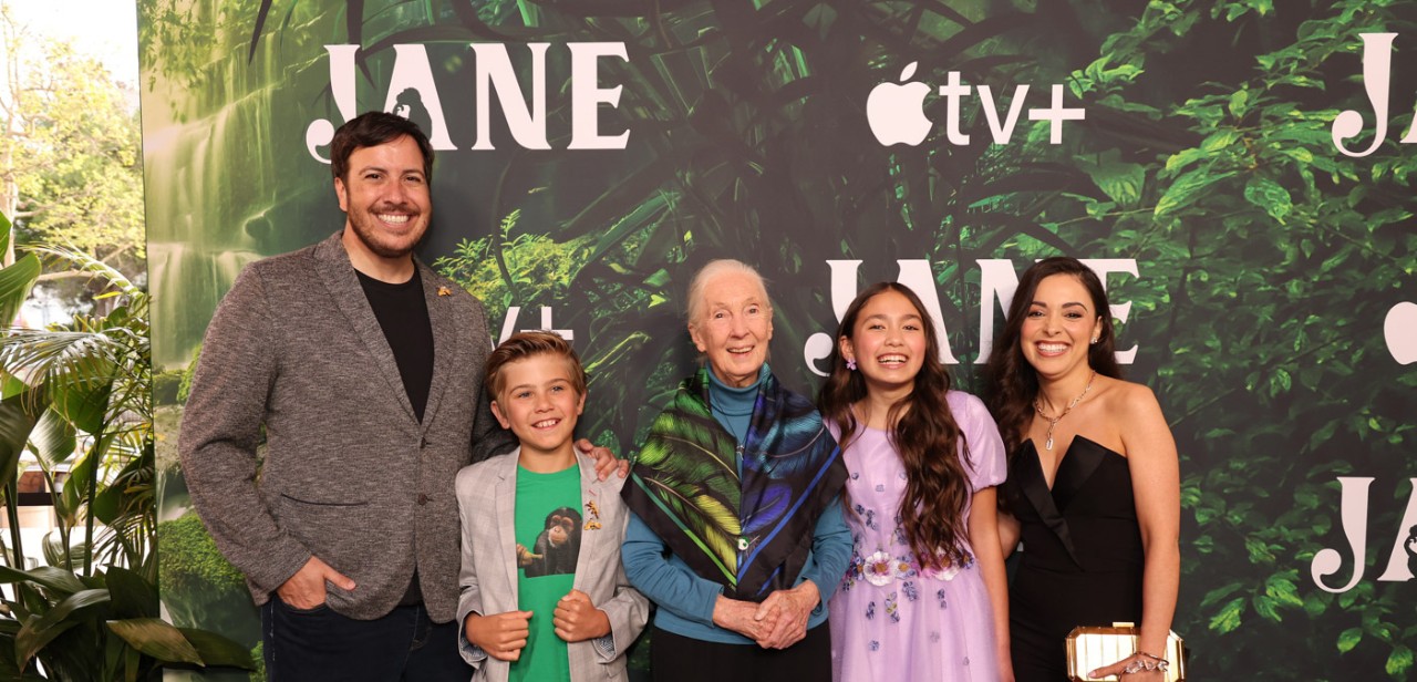 The cast and producer of "Jane" stand in front of a promotional poster of the show.