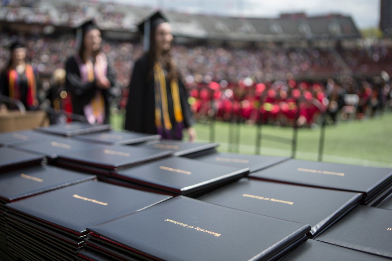 College students walk across the stage celebrating graduation from University of Cincinnati