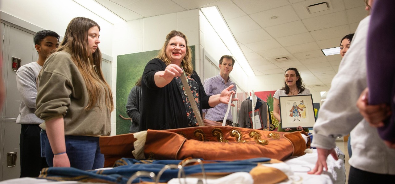  Elizabeth Payne (center), assistant professor of costume design and curator, shows UC honors students the detailed boning and straps incorporated into a vintage opera costumes