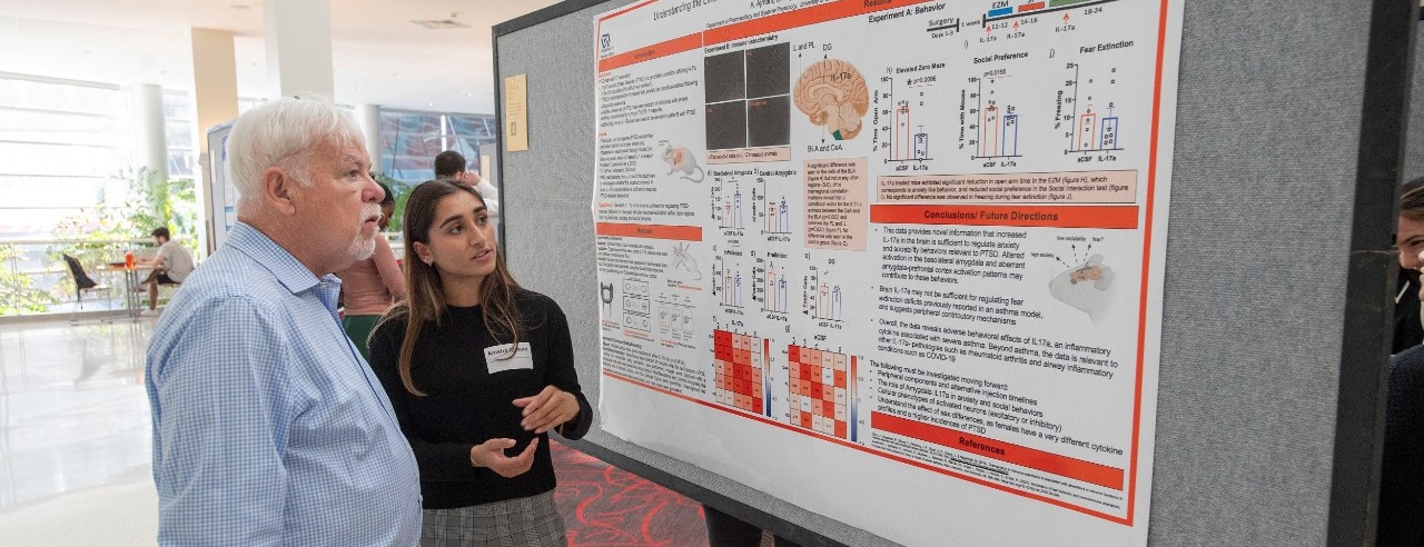 two people look at a research poster together