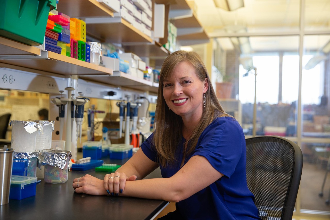 Kathleen Grogan sits at a lab bench.