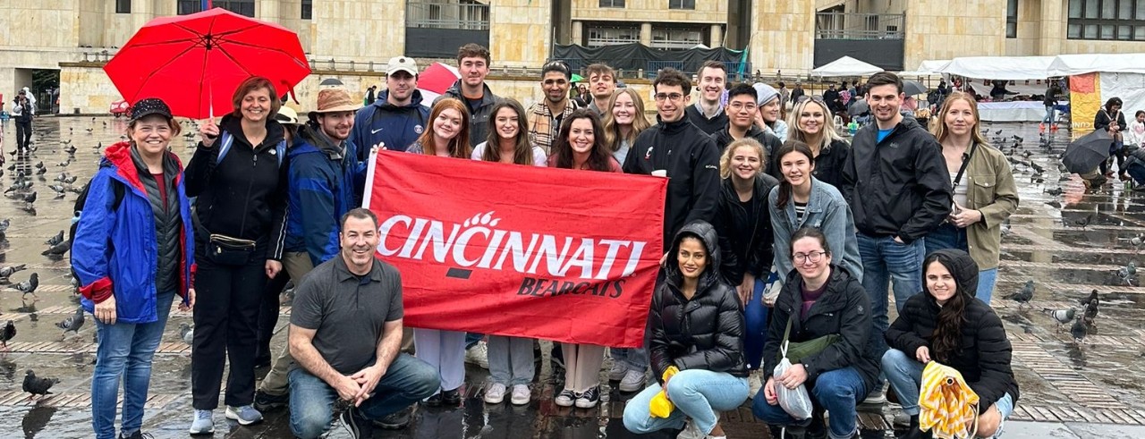 UC College of Law students stand with a University of Cincinnati flag in Colombia.