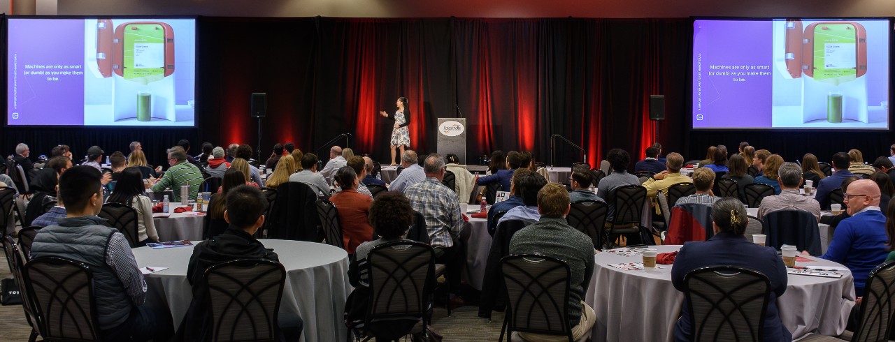 2023 Business Analytics Summit keynote speaker Christina Qi presents her PowerPoint slides to attendees in the Sharonville Convention Center ballroom