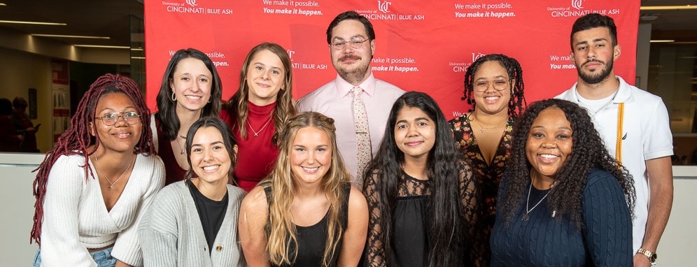 UC Blue Ash student ambassadors group pose in front of UC Blue Ash background