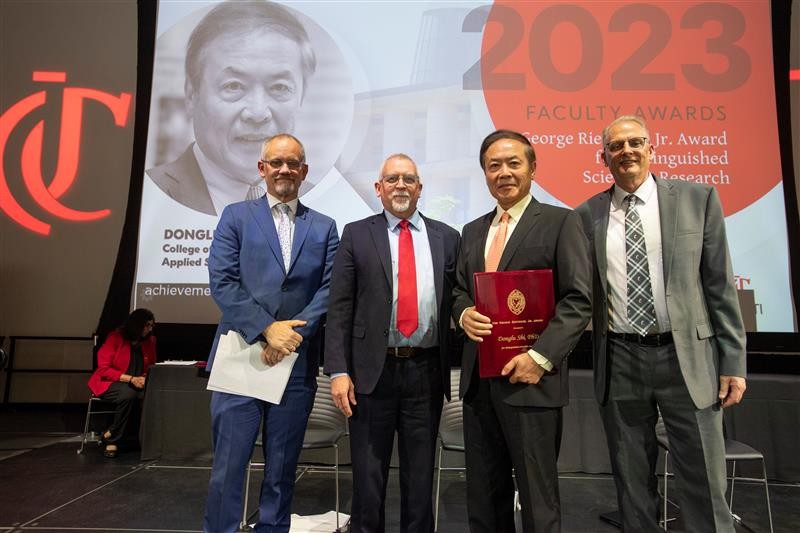 Donglu Shi and other award recipients stand on stage at the annual faculty awards ceremony.