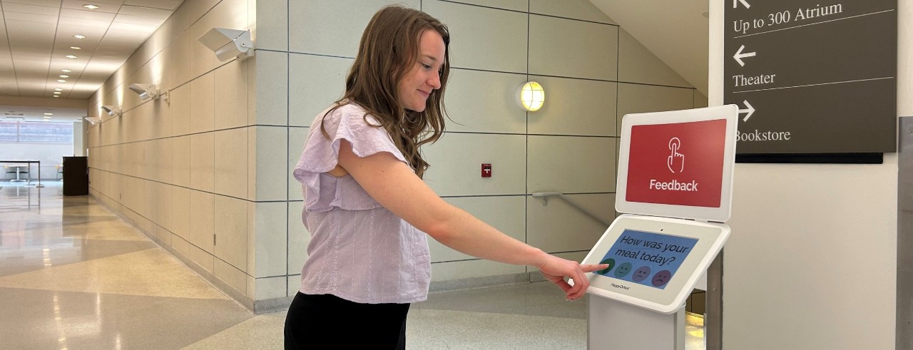 Student using the HappyOrNot Kiosk to share their dining experience.