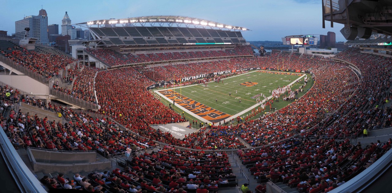 A wide shot of the Cincinnati Bengals stadium at night with the Cincinnati Bearcats football team on the field.