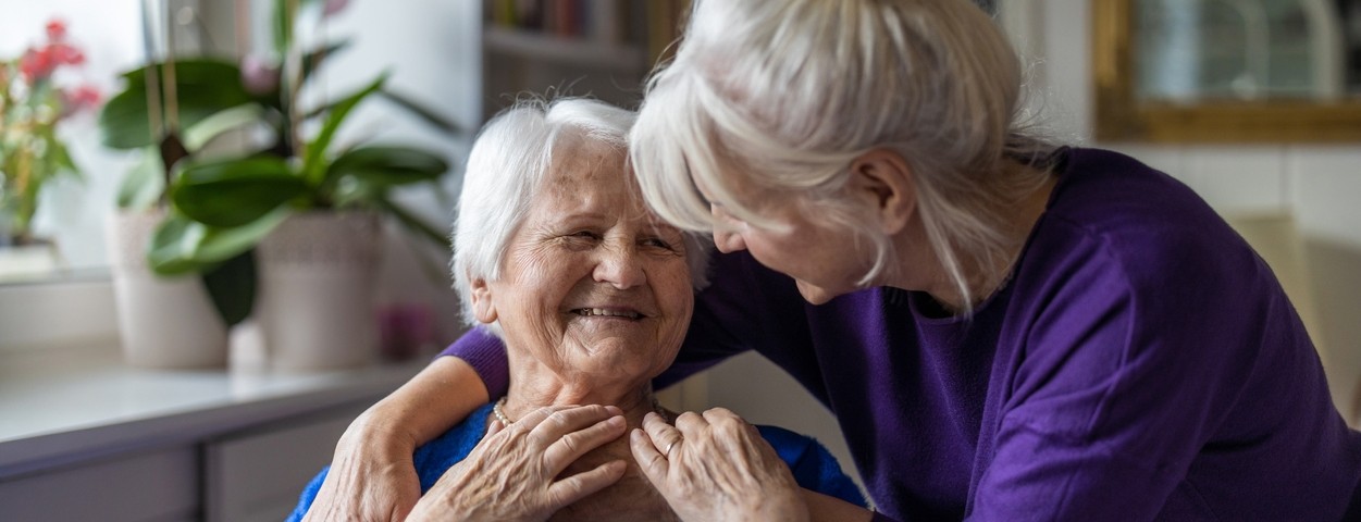 A woman hugs her elderly mother