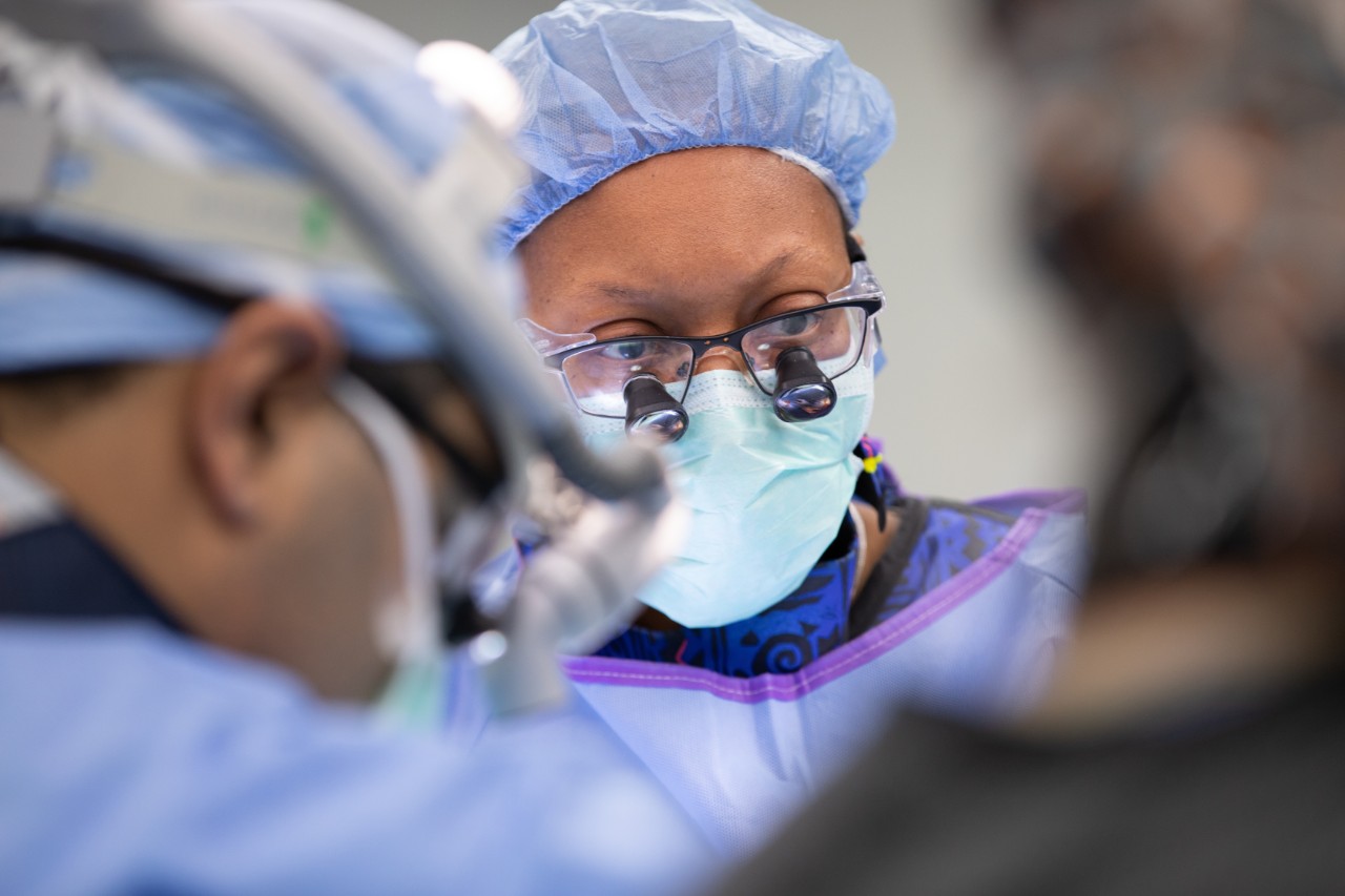 Woman conducting surgery in surgical mask. 