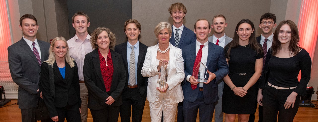 Real estate students pose for a picture with Lindner Dean Marianne Lewis and Service Award winner Laura Brunner.