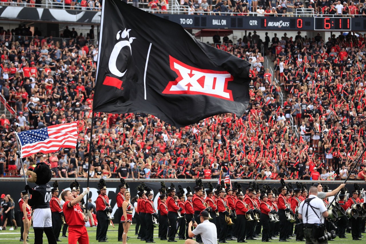 a photo of UC cheerleaders with a Big 12 flag
