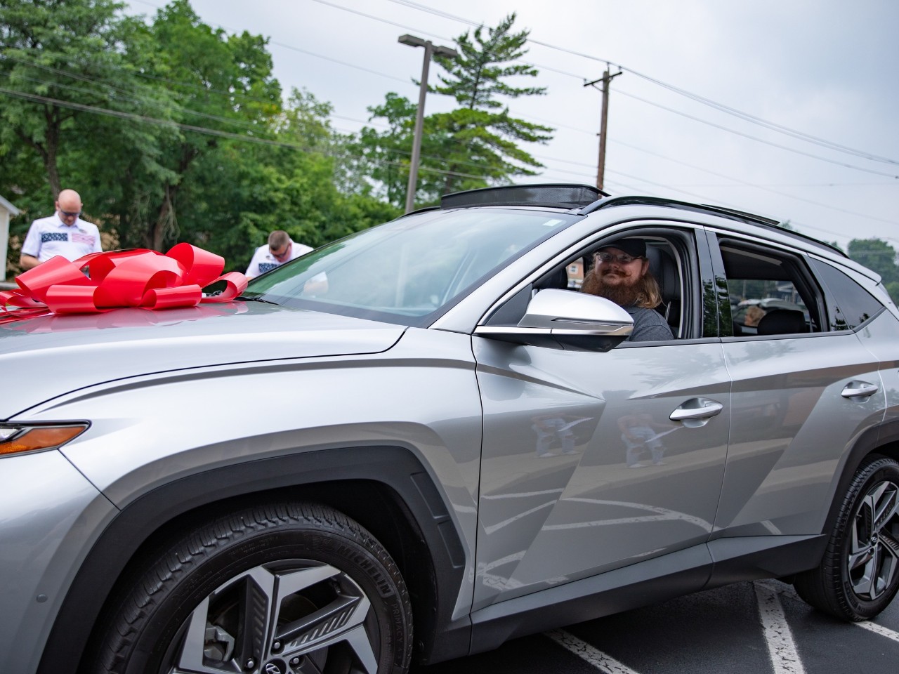 Zach Betsch sitting behind the wheel of his new silver car