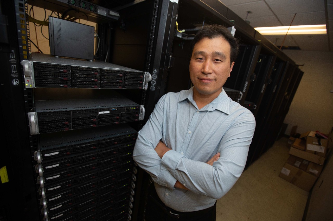 UC chemist Yu Shi stands in front of servers in UC's Advanced Computing Center.