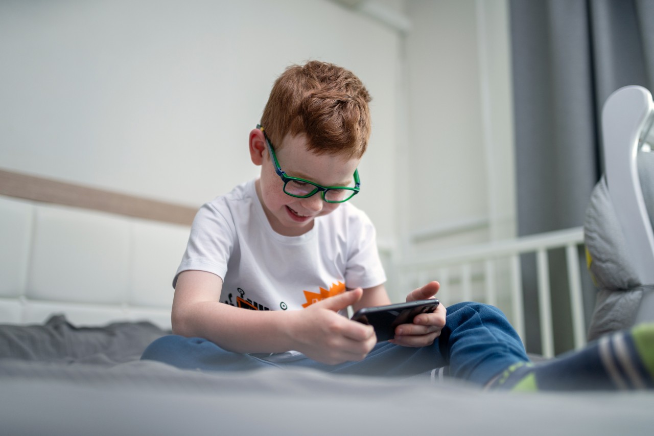 small child holding a hand held tech device