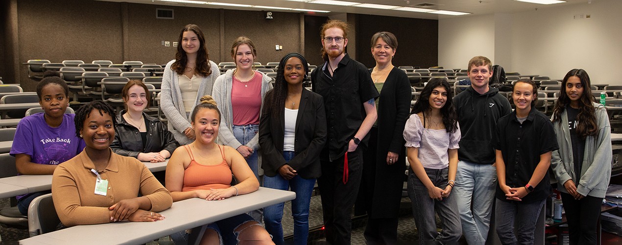 a group of students with two professors in an auditorium classroom