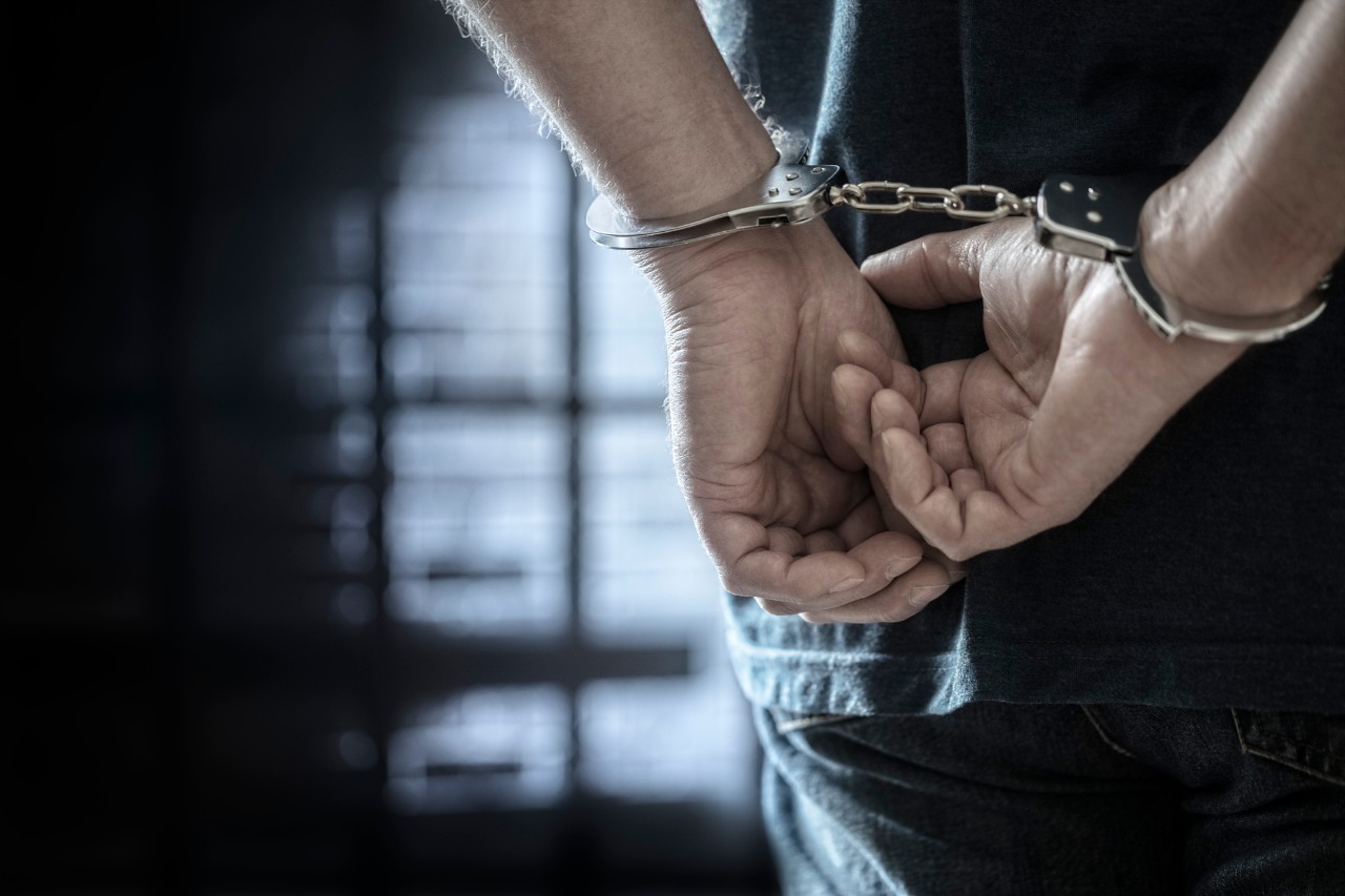 handcuffs behind a male prisoner's back