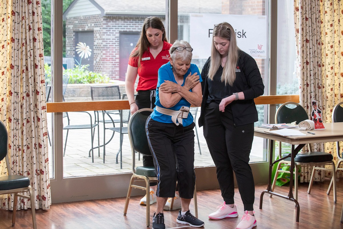 Students assist patient getting up
