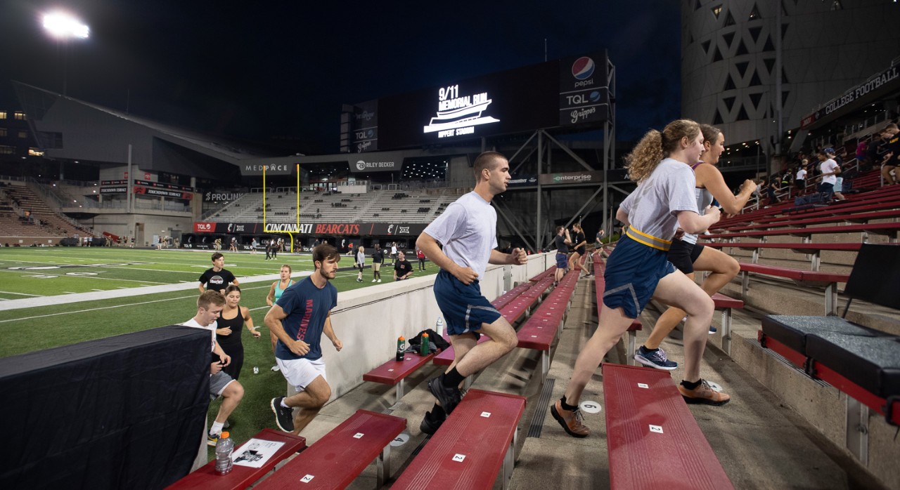 UC students run the steps at Nippert Stadium.