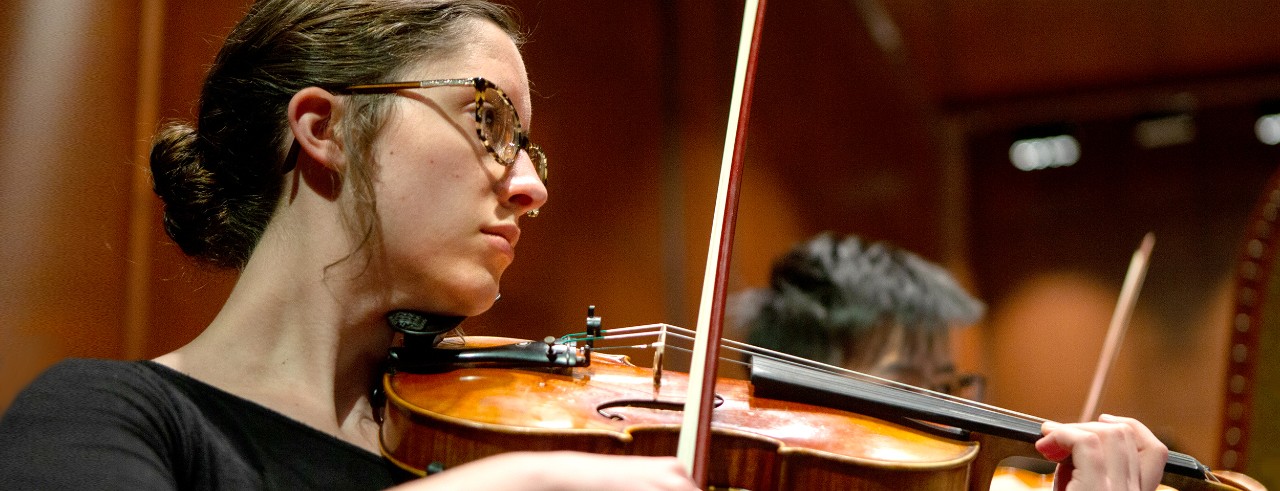 A CCM orchestra student performs on stage