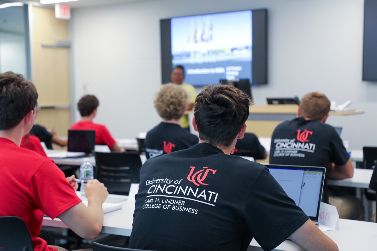 An IKEA employee presents in front of Lindner first years in a classroom.