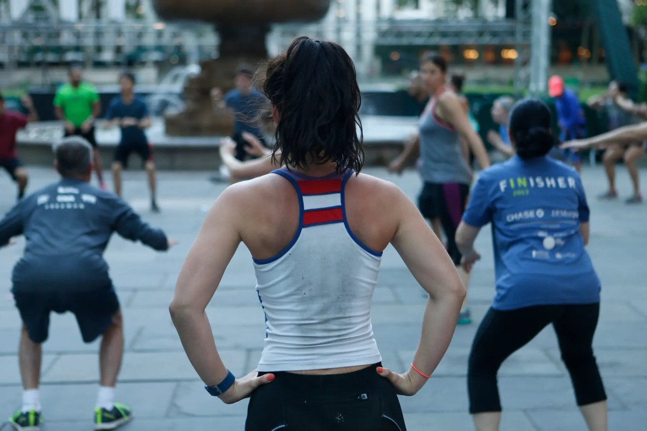 a photo of three people from behind at an outdoor workout