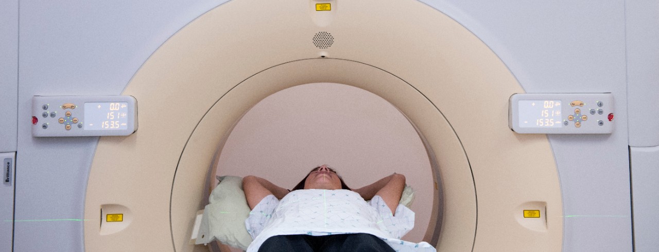 A person lays inside of a CT machine